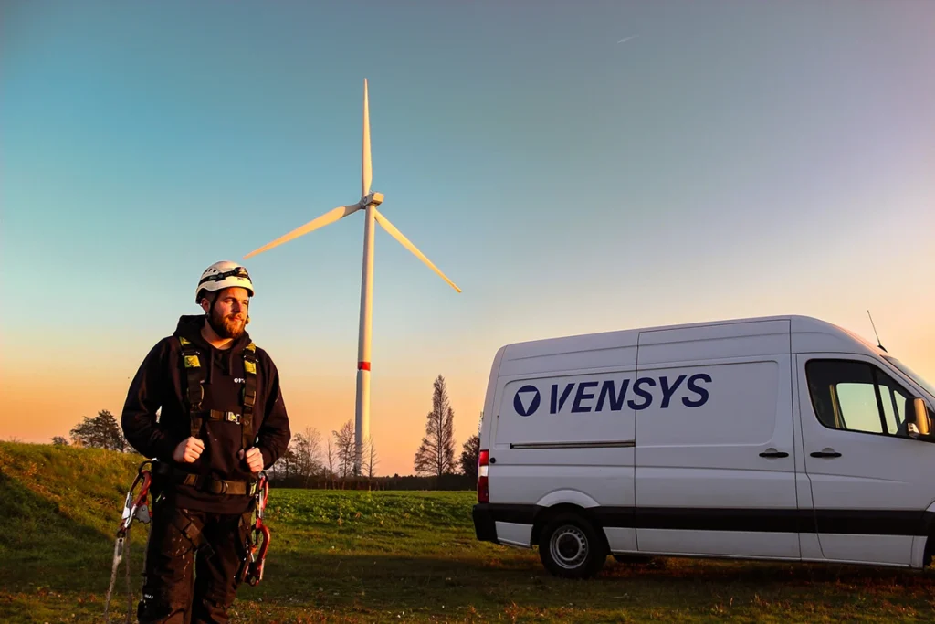 Techniker mit Ausrüstung vor Windrad